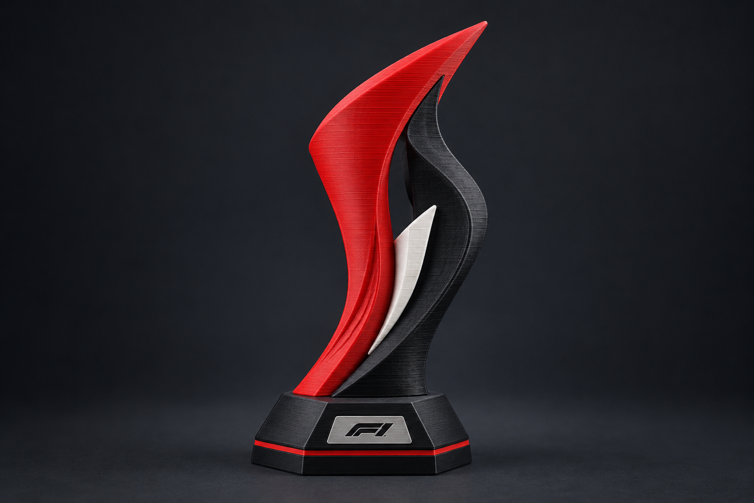 Formula 1 trophy concept with red and black aerodynamic ribbons on a display base.